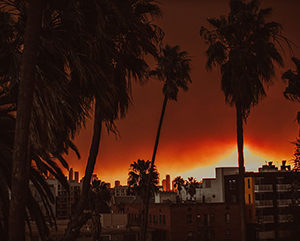 Fire glows in the background of a Los Angeles skyline
