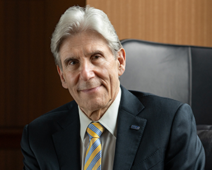 Head-and-shoulders photo of Julio Frenk in charcoal-gray jacket and blue-and-gold tie