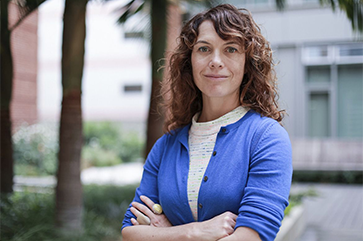 A head-and-shoulders photo of Amy Rowat in a blue cardigan with arms crossed.