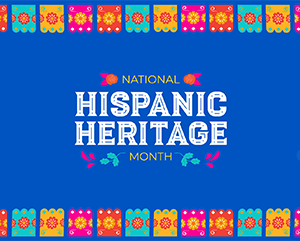 A vibrant graphic celebrating National Hispanic Heritage Month. The background is deep blue with subtle floral and leaf patterns. Brightly colored papel picado banners—orange, pink, blue, and yellow—line the top and bottom edges, each with intricate cut-out designs. Centered text reads “NATIONAL HISPANIC HERITAGE MONTH,” with “HISPANIC HERITAGE” in large, bold white decorative font, and “NATIONAL” and “MONTH” in smaller font flanked by floral icons.