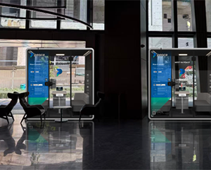 Two modern soundproof booths are positioned side by side in a sleek indoor space.