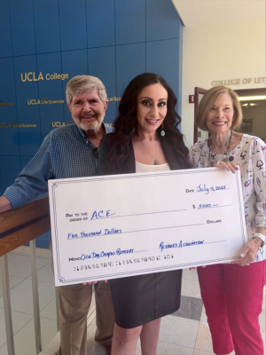 363 – 241 – kayla story (1) Three people holding a giant check.
