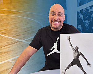 Adam Bradley with Air Jordan book in front of him and basketball court behind him