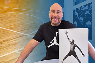 Adam Bradley with Air Jordan book in front of him and basketball court behind him