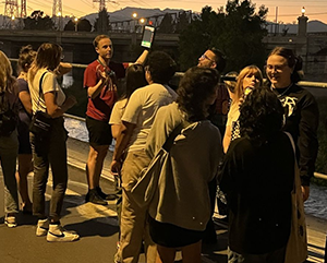 Joey Curti holds up tablet at a dusk bat walk along the Los Angeles River