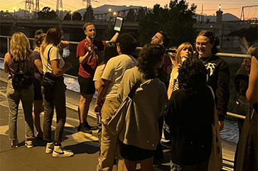 Joey Curti holds up tablet at a dusk bat walk along the Los Angeles River