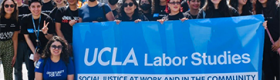 Department of Labor Studies gather around a blue banner