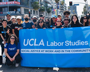 May+Day-363-241 Department of Labor Studies gather around a blue banner