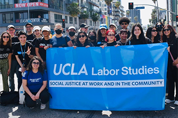 Department of Labor Studies gather around a blue banner