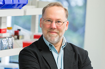 Fred Ramsdell in light blue shirt and dark jacket in laboratory