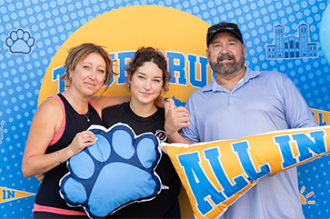 A female student posing with her mother and father.