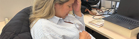 A woman with her hand on her head and stomach on her pregnant belly