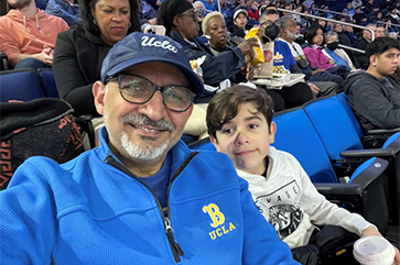 Alumnus Ihab Shahawi with his grandson at a UCLA basketball game.
