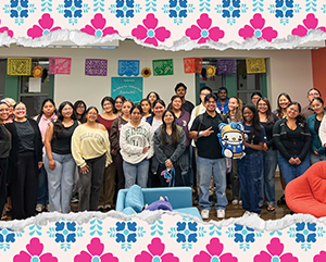 UE_NewsroomphotoExcelenciaScholars_v2 (2)-363-241 Group photo of Excelencia Scholars against a wall, framed with papel picado–inspired illustrated banners