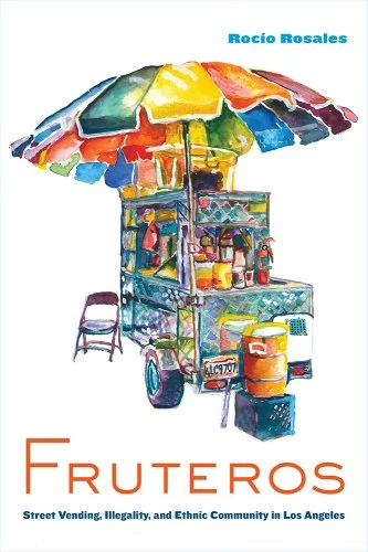 Colorful illustrated book cover showing a fruit cart under a rainbow umbrella, with containers of fruit and a folding chair beside it. Title: Fruteros. Author: Rocío Rosales. Subheading about street vending in Los Angeles.