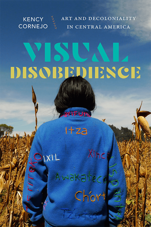 A person with shoulder-length dark hair, seen from behind, stands in a cornfield wearing a blue jacket with colorful embroidered words. Above are the book title Visual Disobedience and author Kency Cornejo.