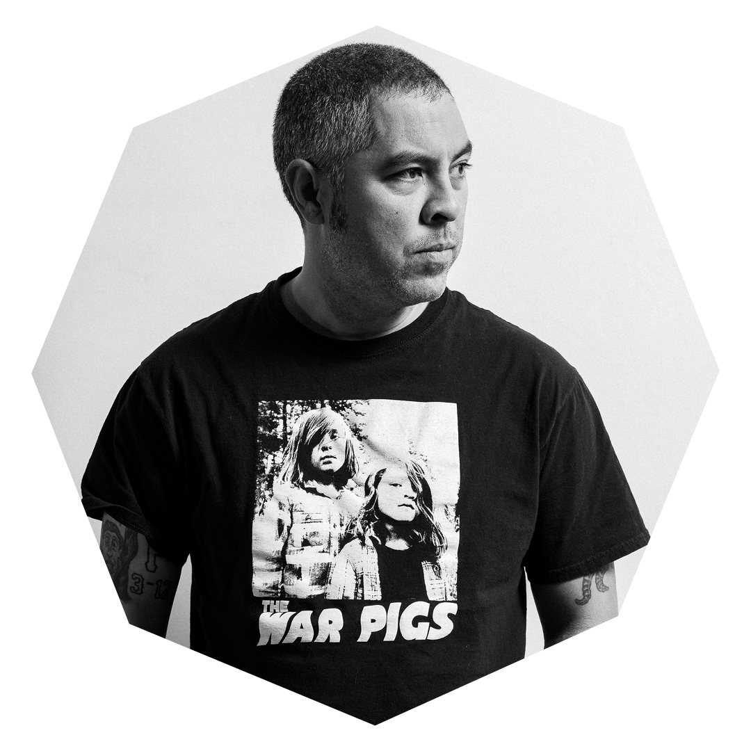 A black-and-white photo of a man in a War Pigs t-shirt looking to the right