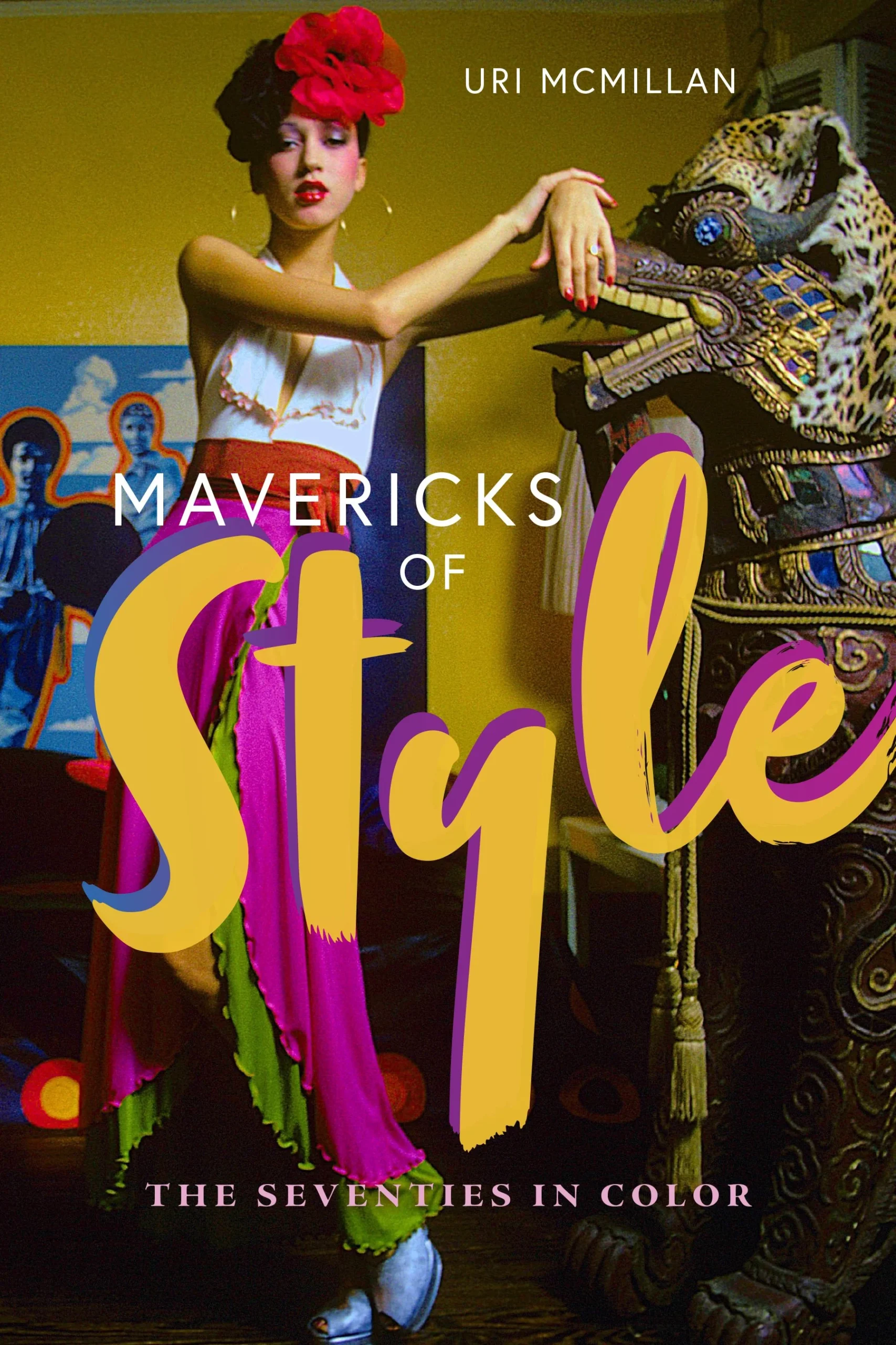 A woman in colorful, eclectic clothing and a red headpiece poses next to a large ornate statue. The book title Mavericks of Style: The Seventies in Color and author Uri McMillan appear on the cover.