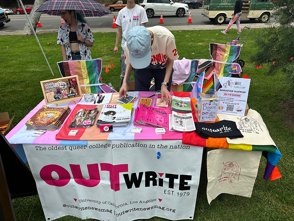 Christopher setting up OutWrite’s table at a local pride event during June 2023.